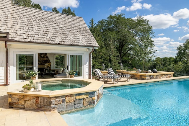 view of pool featuring a patio area and a pool with connected hot tub