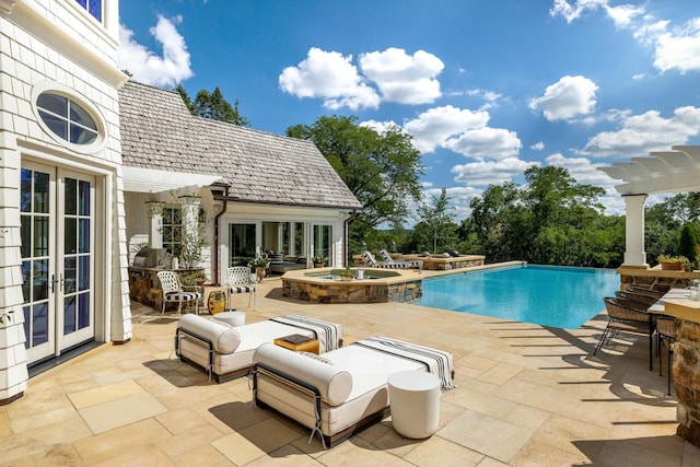 view of swimming pool with a pergola, a patio, a pool with connected hot tub, and french doors