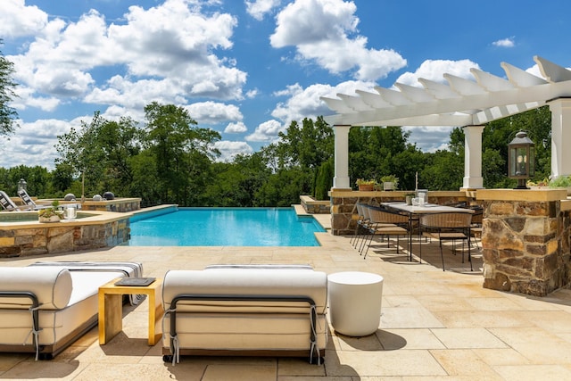 view of swimming pool with a pergola, a patio area, exterior kitchen, and an infinity pool