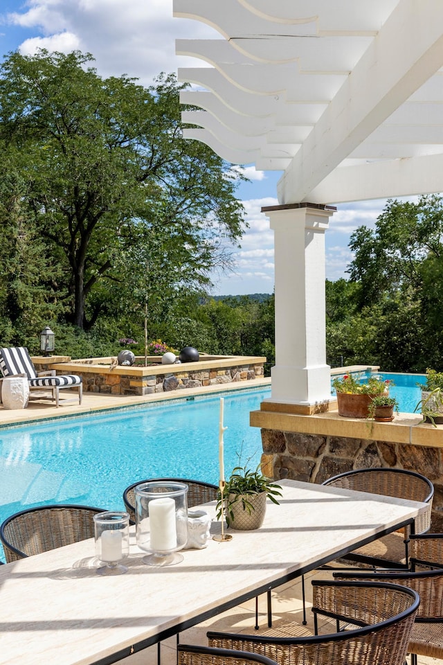 outdoor pool with outdoor dining space, a pergola, and a patio area