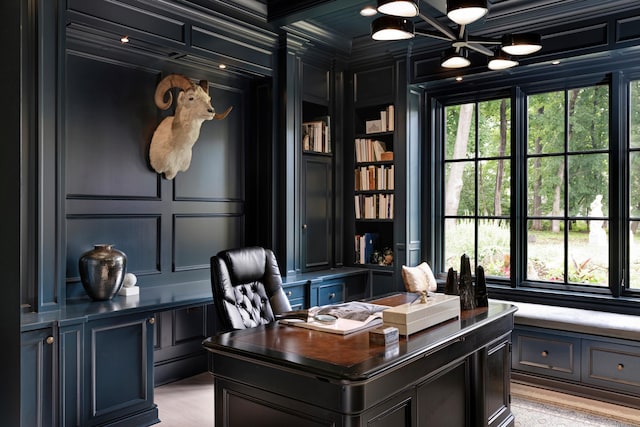 office space with crown molding, a decorative wall, and plenty of natural light
