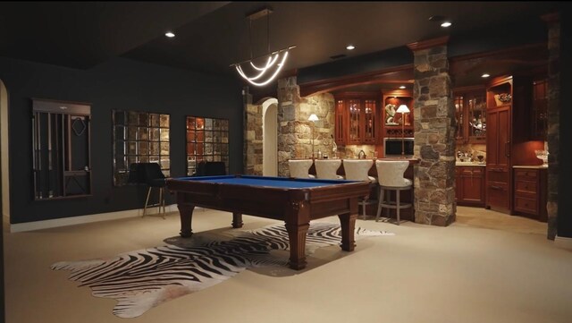 rec room featuring arched walkways, decorative columns, wet bar, billiards, and light colored carpet