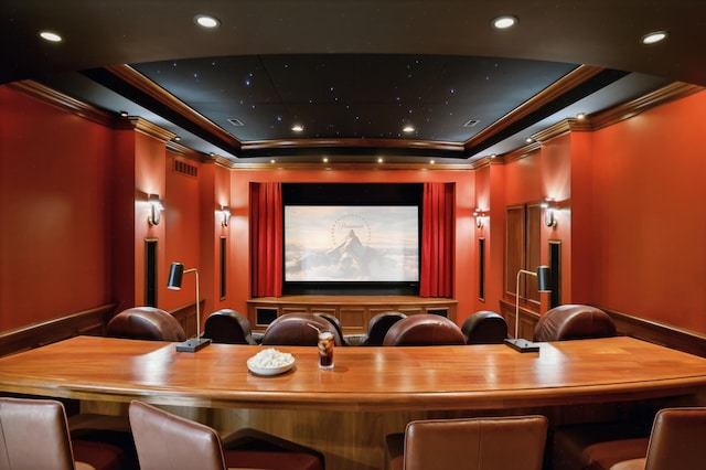 home theater with recessed lighting, visible vents, a tray ceiling, and ornamental molding