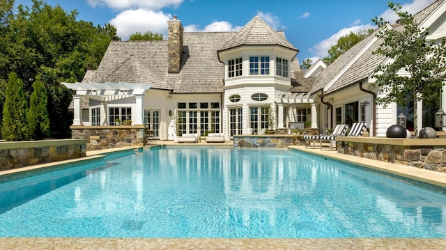 exterior space with a pergola, a chimney, a patio area, an outdoor pool, and french doors