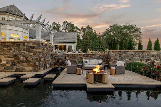 exterior space with an outdoor living space with a fire pit, a pergola, and a water view