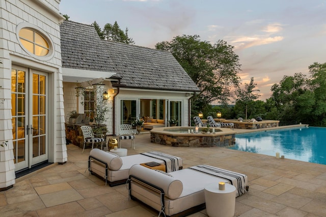outdoor pool featuring a patio area, a fire pit, and french doors
