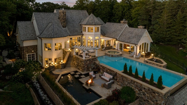view of swimming pool featuring a patio area, an outdoor living space with a fire pit, and a pool with connected hot tub