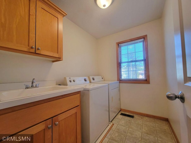 laundry area featuring visible vents, baseboards, a sink, cabinet space, and washing machine and clothes dryer