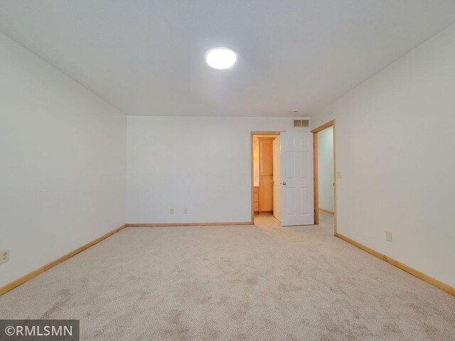 unfurnished room with carpet flooring, baseboards, and visible vents