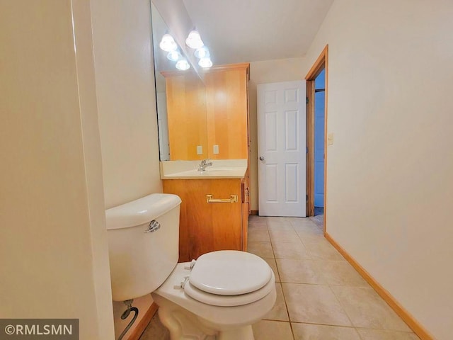 bathroom featuring toilet, tile patterned floors, vanity, and baseboards