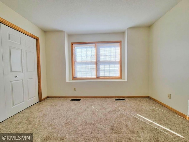unfurnished bedroom with visible vents, baseboards, and carpet floors