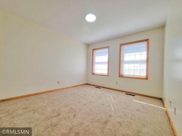 carpeted spare room with baseboards and visible vents