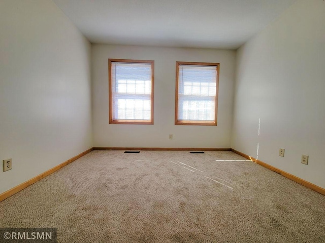 carpeted spare room with baseboards and visible vents