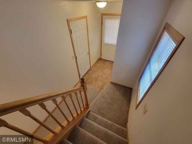 stairs featuring baseboards and carpet floors