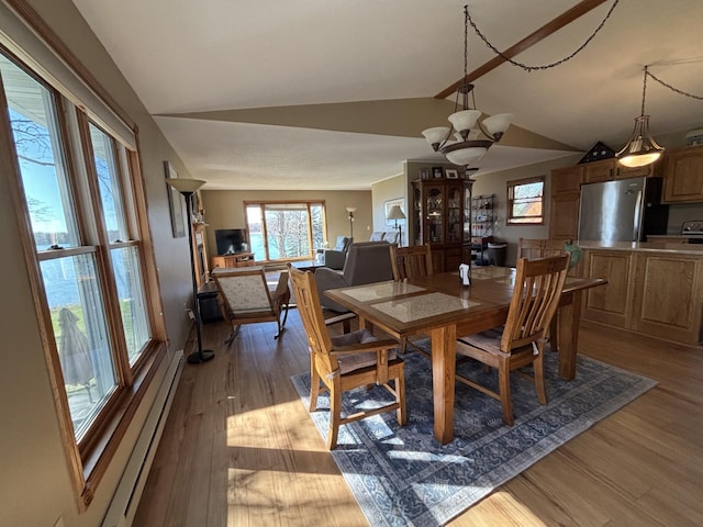 26837 Lake Ethel Rd, Girard Twp, MN 56515 - dining area with a baseboard radiator, vaulted ceiling, and wood finished floors
