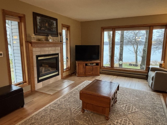 26837 Lake Ethel Rd, Girard Twp, MN 56515 - living area with a tile fireplace, wood finished floors, and a baseboard heating unit