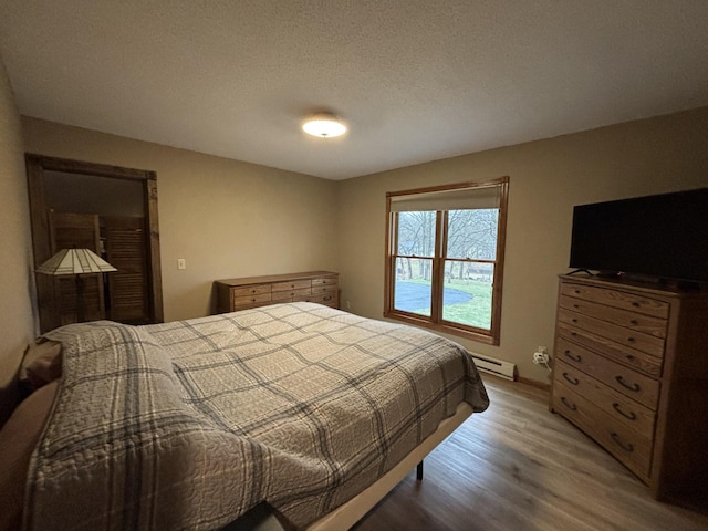 26837 Lake Ethel Rd, Girard Twp, MN 56515 - bedroom with wood finished floors and baseboard heating