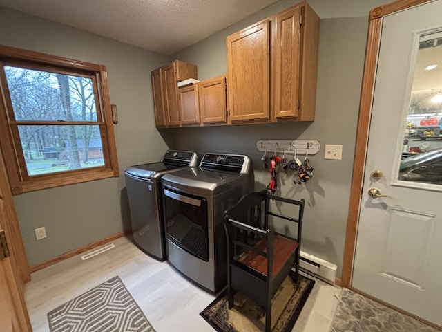 26837 Lake Ethel Rd, Girard Twp, MN 56515 - laundry room with cabinet space, baseboard heating, light wood-style flooring, baseboards, and separate washer and dryer