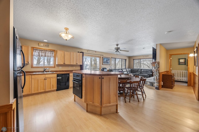 15924 Blackhawk Rd, Lake Park, MN 56554 - kitchen featuring black appliances, a sink, a textured ceiling, light wood-style floors, and a kitchen island