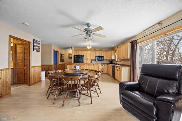 15924 Blackhawk Rd, Lake Park, MN 56554 - dining area featuring a wainscoted wall, light wood finished floors, a ceiling fan, a textured ceiling, and wooden walls