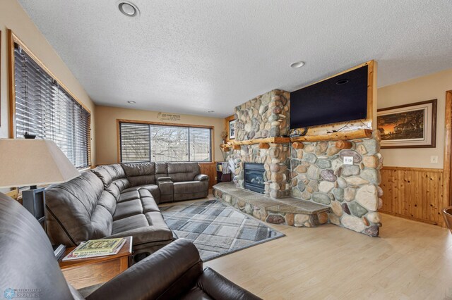 15924 Blackhawk Rd, Lake Park, MN 56554 - living room with a textured ceiling, wood finished floors, a fireplace, a wainscoted wall, and wooden walls
