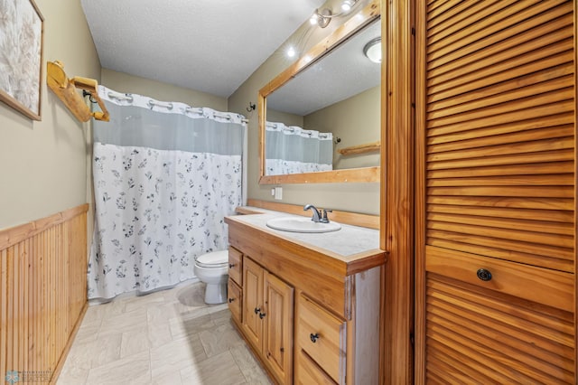 15924 Blackhawk Rd, Lake Park, MN 56554 - bathroom with toilet, vanity, a shower with curtain, a wainscoted wall, and a textured ceiling