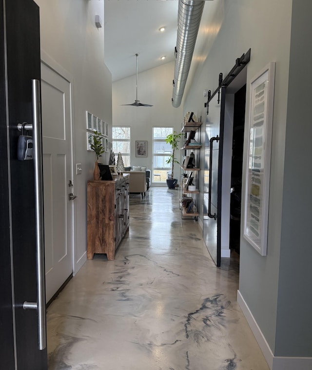 4405 17th Ave NW, Sauk Rapids, MN 56379 - hallway featuring high vaulted ceiling, a barn door, baseboards, and concrete floors