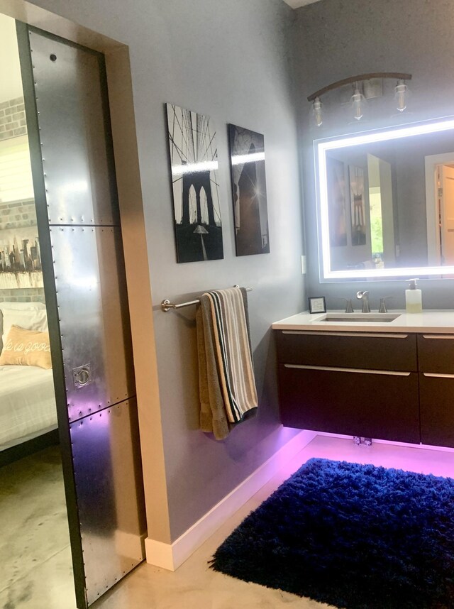 4405 17th Ave NW, Sauk Rapids, MN 56379 - ensuite bathroom featuring concrete flooring, vanity, baseboards, and connected bathroom
