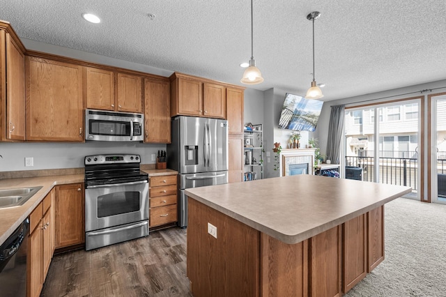 kitchen with brown cabinets, a textured ceiling, appliances with stainless steel finishes, and a fireplace
