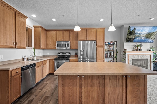 kitchen featuring a center island, a textured ceiling, dark wood-type flooring, and appliances with stainless steel finishes