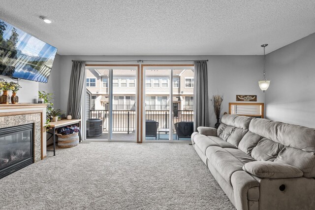 living room featuring a fireplace, carpet, and a textured ceiling