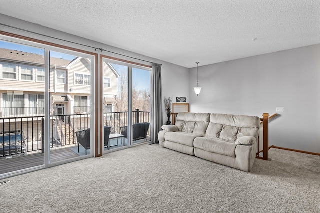 carpeted living area with visible vents, baseboards, and a textured ceiling