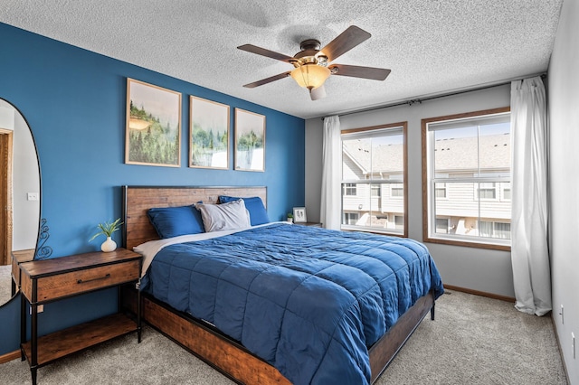 carpeted bedroom featuring baseboards, a ceiling fan, and a textured ceiling