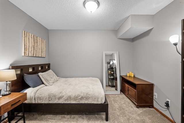 bedroom with a textured ceiling and light colored carpet