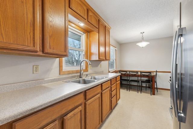 11749 Crooked Lake Blvd NW, Coon Rapids, MN 55433 - kitchen with stainless steel refrigerator, brown cabinets, light countertops, and a sink