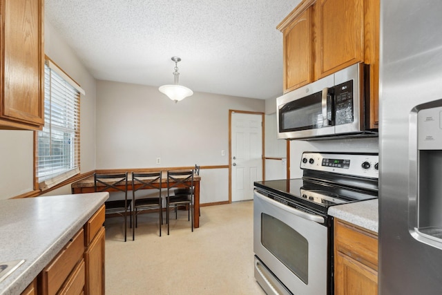 11749 Crooked Lake Blvd NW, Coon Rapids, MN 55433 - kitchen featuring brown cabinetry, stainless steel appliances, a textured ceiling, and decorative light fixtures