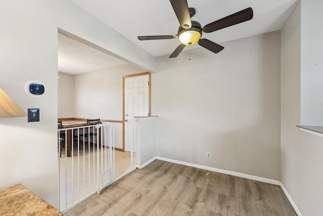 11749 Crooked Lake Blvd NW, Coon Rapids, MN 55433 - spare room featuring a ceiling fan, wood finished floors, and baseboards