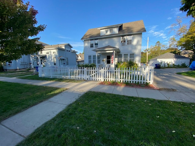 traditional style home featuring a shingled roof, a fenced front yard, and a front lawn