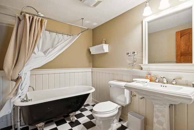 8434 Big Whitefish Narrows, Pine River, MN 56474 - bathroom with tile patterned floors, a textured ceiling, toilet, a wainscoted wall, and visible vents