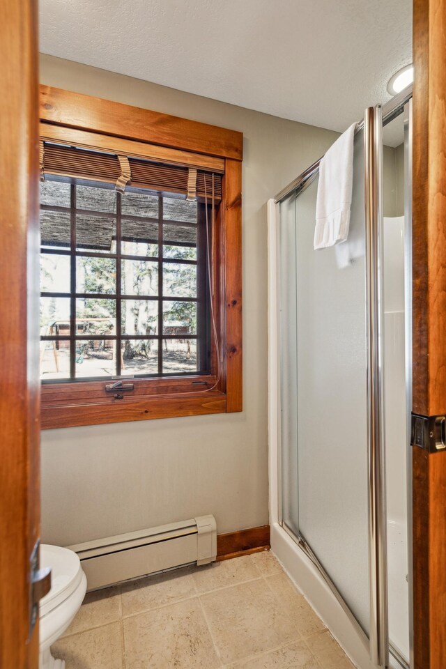 8434 Big Whitefish Narrows, Pine River, MN 56474 - bathroom with baseboards, toilet, a baseboard radiator, tile patterned floors, and a stall shower