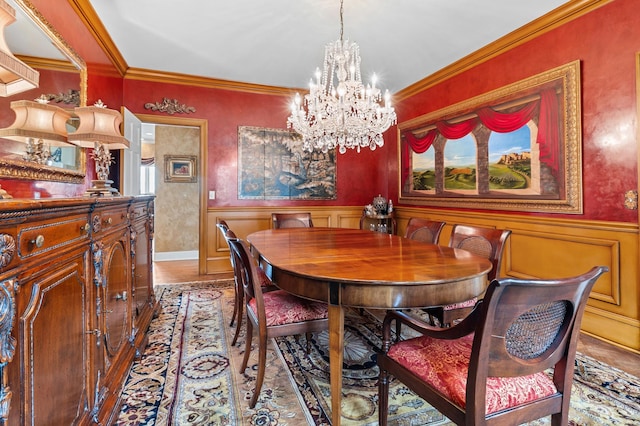 dining room featuring an inviting chandelier, a wainscoted wall, and ornamental molding