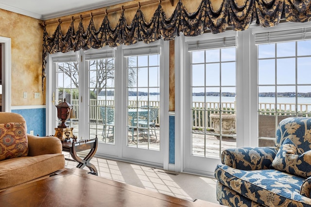 entryway featuring crown molding, a water view, and carpet floors