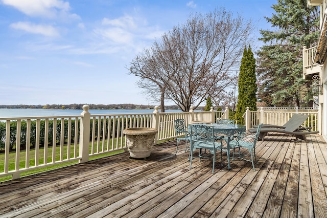 wooden deck with outdoor dining area and a water view