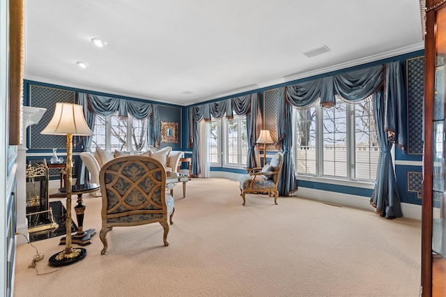 carpeted living area featuring crown molding, baseboards, wallpapered walls, and visible vents