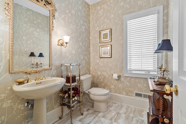 bathroom featuring wallpapered walls, toilet, and visible vents