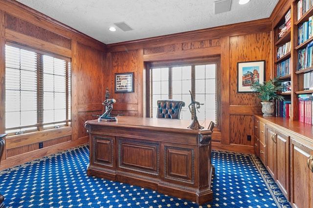 home office with wooden walls and a textured ceiling