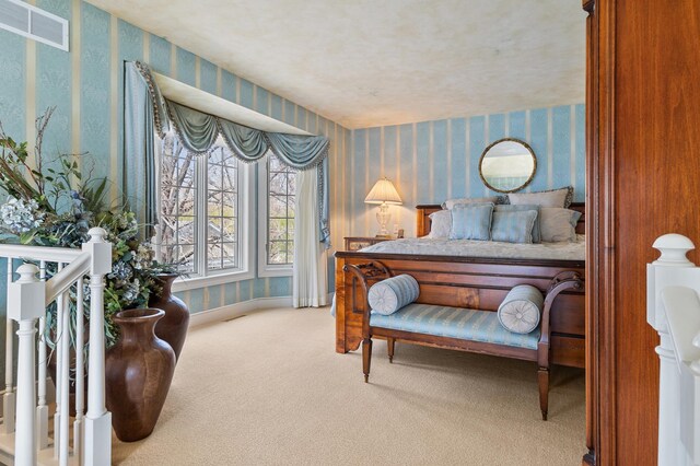 bedroom featuring visible vents, baseboards, carpet floors, and wallpapered walls