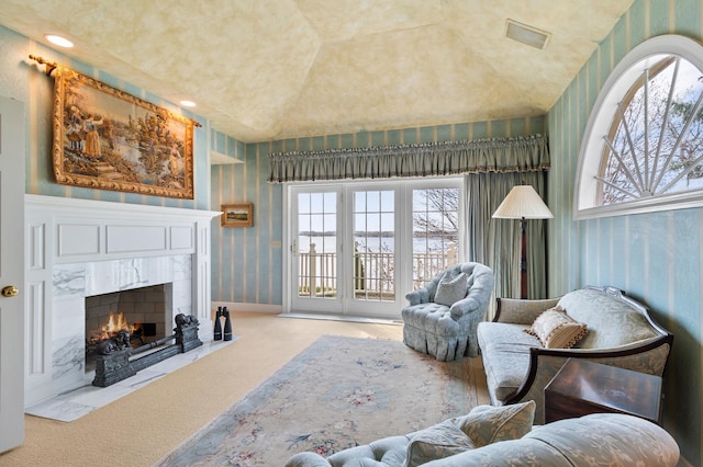 living area featuring carpet flooring, a premium fireplace, wallpapered walls, and plenty of natural light