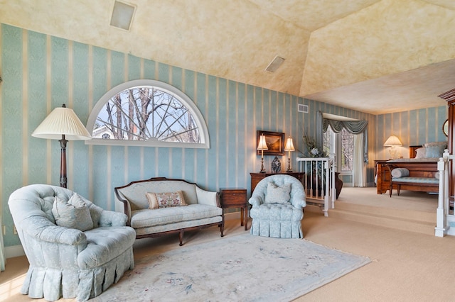 living area with visible vents, carpet flooring, a wealth of natural light, and wallpapered walls