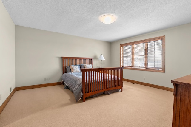 bedroom with baseboards, carpet flooring, a textured ceiling, and visible vents